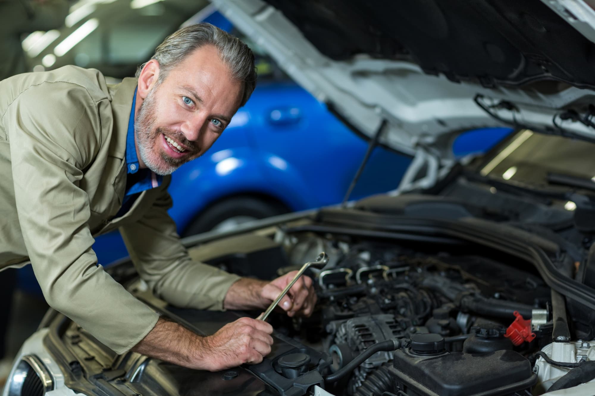 Mechanic working on a vehicle engine at Ten Minute Oil Change