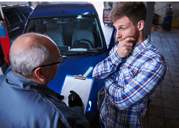Technicians discussing vehicle maintenance notes in the shop
