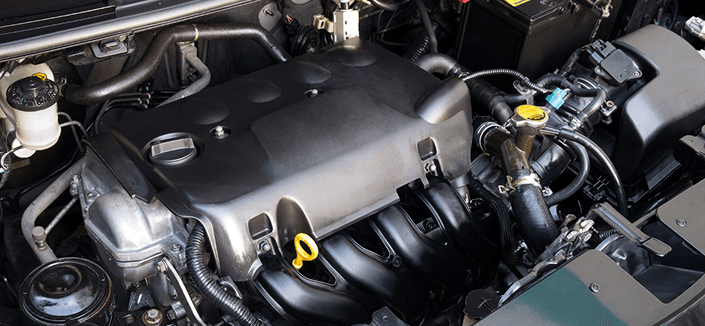 Technician performing vehicle maintenance under the hood