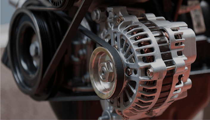 Close-up of a car alternator with serpentine belt around the pulley