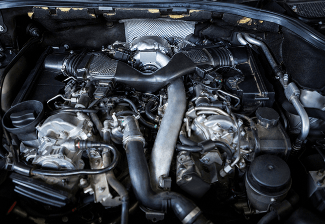 Close-up of a modern car engine bay with hoses and mechanical components