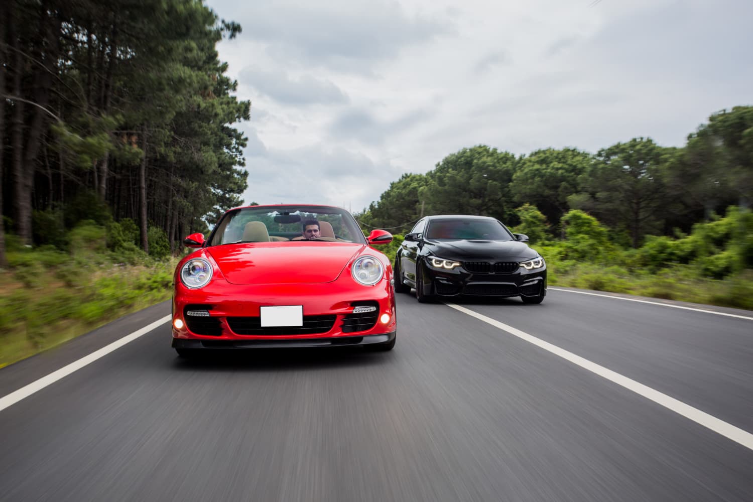 Sports cars on a road at dusk