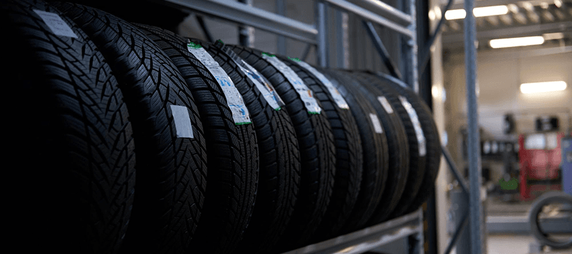 Row of used tires stored on industrial shelving in a workshop