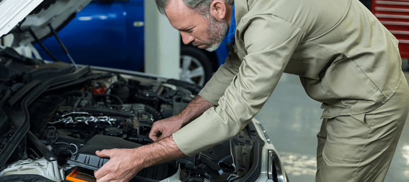 Mechanic inspecting a car engine under the hood