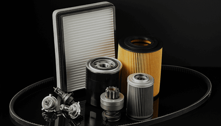 Engine air filter, oil filter, and automotive parts on a dark surface