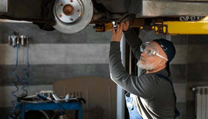 Technician working under a vehicle on a hydraulic lift