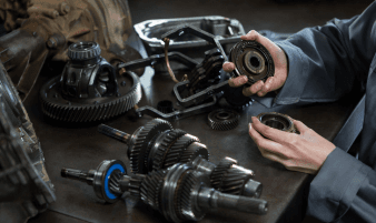 Technician performing transmission service on a vehicle