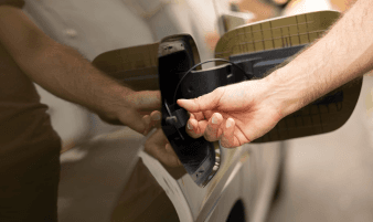 Technician replacing a gas cap on a vehicle