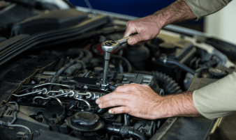 Technician replacing spark plugs during a tune-up