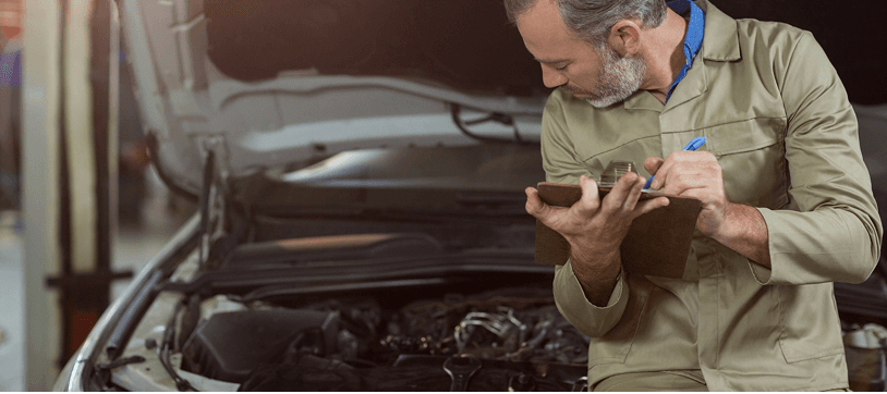 Ten Minute Oil Change technician inspecting a vehicle for transmission service