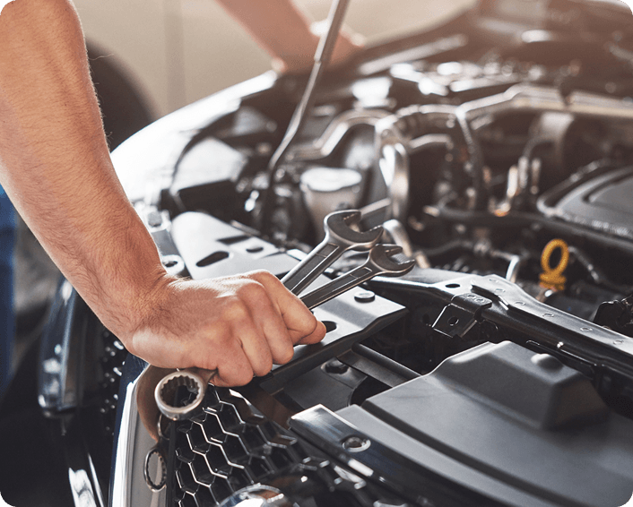 Mechanic performing vehicle maintenance under the hood