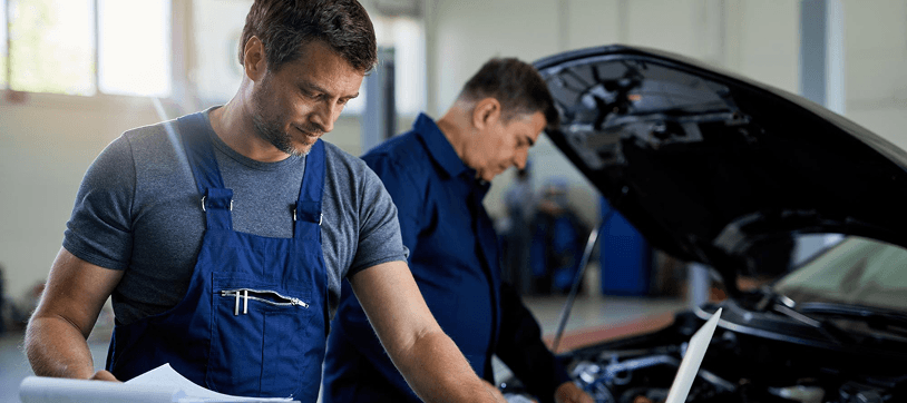 Mechanics performing auto repair in a professional garage