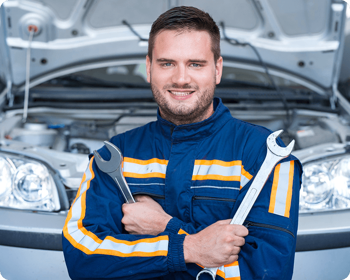 Ten Minute Oil Change technician with wrenches beside a vehicle
