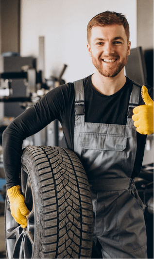 Mechanic holding a car tire at Ten Minute Oil Change Garland