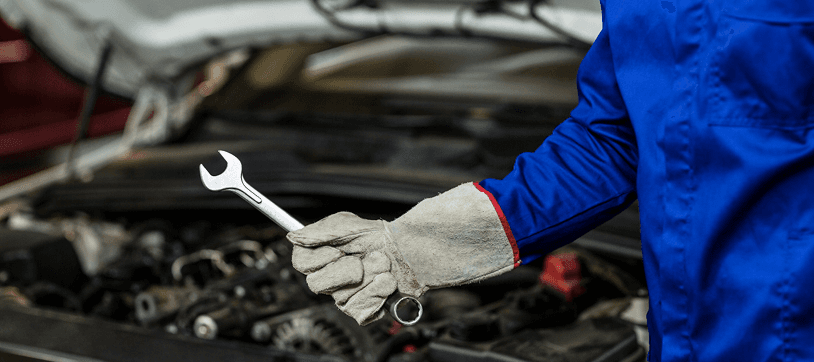 Mechanic performing engine repair at Ten Minute Oil Change Garland