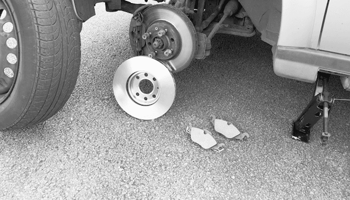 Car brake rotor and pads during a professional brake inspection