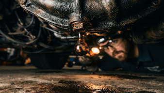 Mechanic working under a vehicle during transmission service