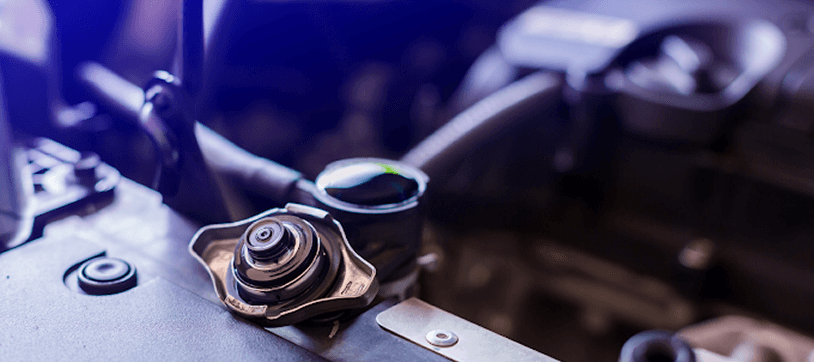 Close-up of a car radiator and engine bay during hose service