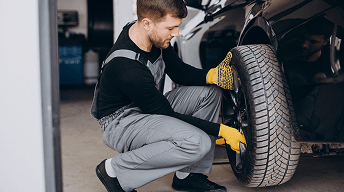 Mechanic working on a vehicle wheel during tire service