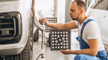 Technician attaching a wheel balancing target plate