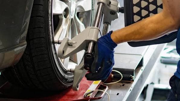 Close-up of vehicle engine and drive components during wheel alignment service