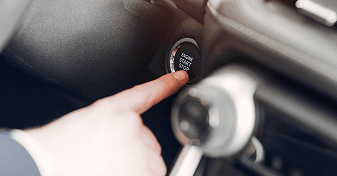 Driver pressing the engine start button