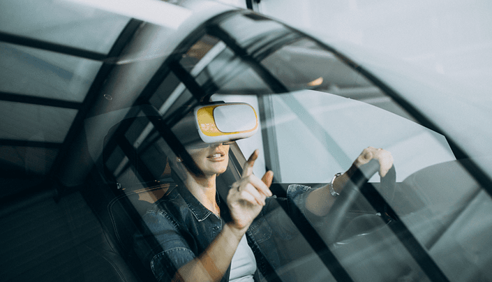 Driver inside a car viewed through the windshield with reflections on the glass