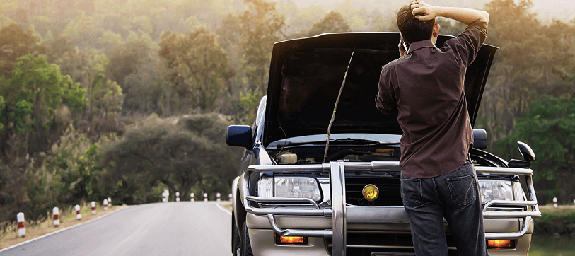 Driver standing beside a car with the hood open on the roadside