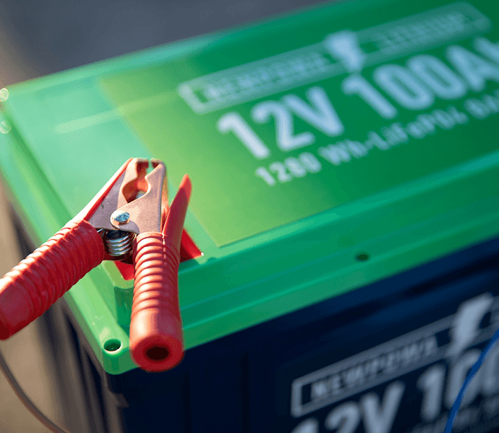 Car battery with jumper cable clamp attached to the terminal