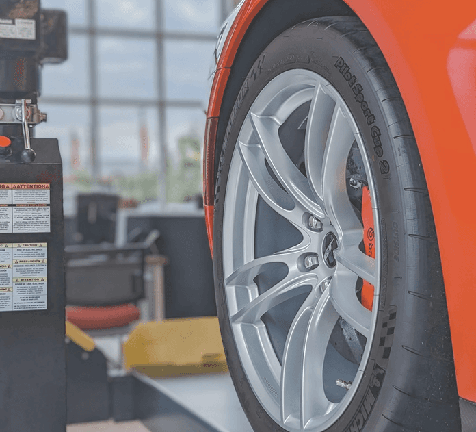 Car wheel on alignment rack in service bay