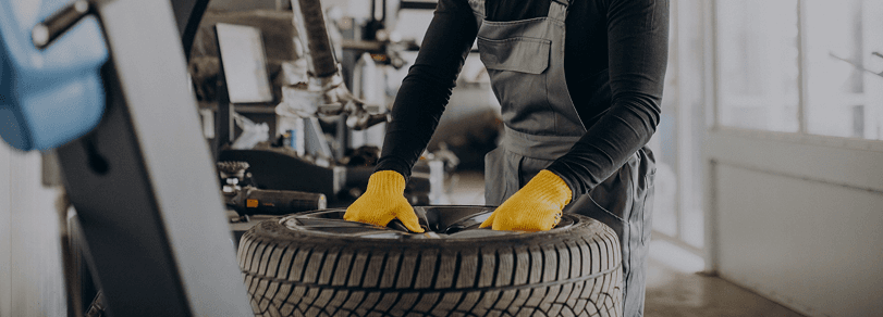 Mechanic servicing a tire on a wheel machine